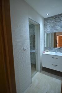 a bathroom with a shower and a sink and a mirror at Appartement pied dans l'eau imi Ouaddar in Imi Ouaddar
