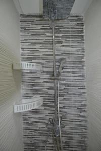 a shower in a bathroom with a wall at Appartement pied dans l'eau imi Ouaddar in Imi Ouaddar