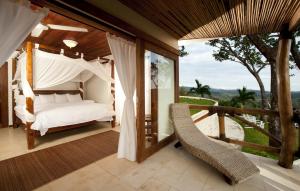 1 dormitorio con 1 cama y balcón con vistas. en Tierra Magnifica Boutique Hotel, en Nosara