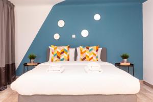 a bedroom with a large bed with a blue wall at Psirri Lofts in Athens