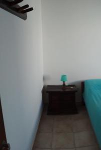 a room with a bed and a table with a lamp at Alquiler por día Choele Choel 1 in Choele Choel