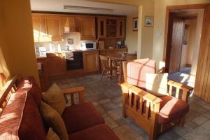 a living room with a couch and a kitchen at Barnwell Farm Cottages Corn cottage in Greyabbey