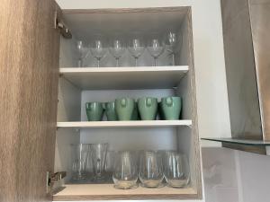 a cupboard with a bunch of glasses in it at Stunning Lake and City View 2BD/2BA in Kent