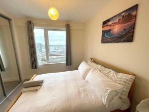 a bedroom with a white bed with a large window at Stunning Lake and City View 2BD/2BA in Kent