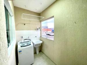 baño con aseo y lavabo y ventana en Expo Center - Apartamento Vila Maria - São Paulo, en São Paulo