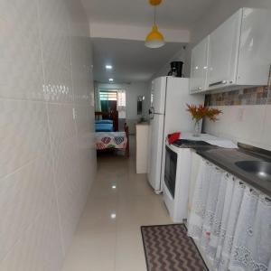 a small kitchen with a sink and a refrigerator at Loft Belas Praias in Arraial do Cabo