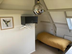 een kleine kamer met een bed en een plafond bij Landhuis 'De Ontspanning' in Axel
