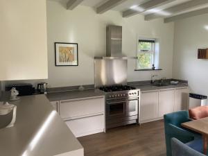 a kitchen with white cabinets and a stove top oven at Landhuis 'De Ontspanning' in Axel