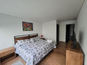 1 dormitorio con 1 cama y TV de pantalla plana en Napoles Suites, en Ciudad de México