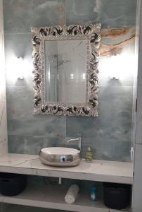 een badkamer met een wastafel en een spiegel aan de muur bij Patio Glamour in Koszalin
