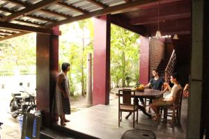 a group of people sitting around a table in a house at Teak house in Yogyakarta
