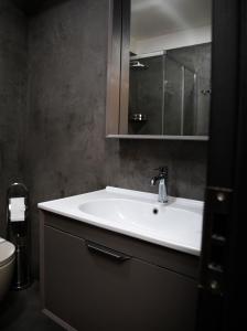 a bathroom with a sink and a mirror and a toilet at Triss Hotel in Tirana