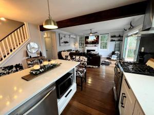 a kitchen and living room with a counter and a stove at Cozy Cabin on the Lake w/ HotTub in Hopatcong