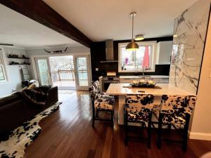 cocina y sala de estar con mesa y sillas en Cozy Cabin on the Lake w/ HotTub, en Hopatcong