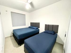 - 2 lits dans une chambre avec des draps bleus dans l'établissement Expo Center - Apartamento Vila Maria - São Paulo, à São Paulo