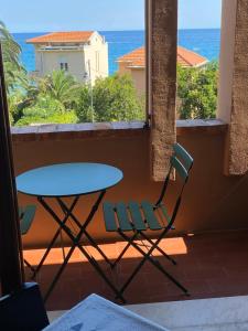 un tavolo e una sedia su un balcone con vista sull'oceano di Varigotti #subitoalmare a Varigotti