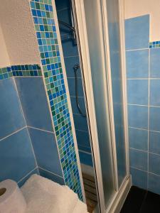 ヴァリゴッティにあるVarigotti #subitoalmareのバスルーム(青いタイル張りの壁のシャワー付)