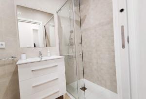 a bathroom with a shower and a sink and a mirror at APARTAMENTOS SANLUCAR CASA D in Sanlúcar de Barrameda