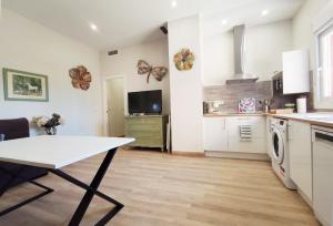 - une cuisine avec une table au milieu d'une pièce dans l'établissement APARTAMENTOS SANLUCAR CASA D, à Sanlúcar de Barrameda