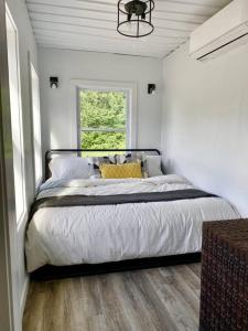 ein Schlafzimmer mit einem Bett in einem Zimmer mit einem Fenster in der Unterkunft Ski Hike Swim Container Cabin in Rumney