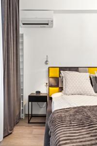 a bedroom with a bed and a night stand with a table at Brand New Studio - Old Town in Bucharest