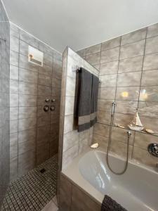 een badkamer met een douche en een bad bij „Partanum“ in Garmisch-Partenkirchen
