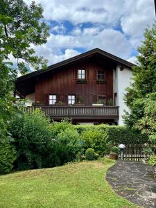 een groot houten huis met een balkon en een tuin bij „Partanum“ in Garmisch-Partenkirchen
