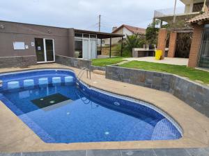 a large blue swimming pool in front of a house at Espectacular Bahía Bonita depto 43 in Concón