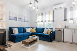 Il comprend un salon avec un canapé bleu et une cuisine. dans l'établissement Luxury seaside apartment in Flisvos Palaio Faliro, à Athènes