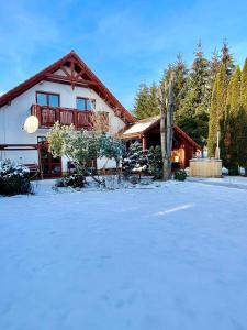una casa con nieve delante en KAPINA sk - Holiday Homes, en Liptovská Sielnica