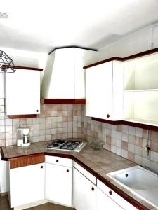 uma cozinha com armários brancos e um forno com placa de fogão em Appartement Cosy Pointe-à-Pitre em Pointe-à-Pitre