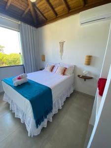 1 dormitorio con 1 cama blanca grande y ventana en Taipu de Fora - Villa Ohana Flats en Taipu