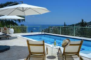 Mastorátika的住宿－Loggos View House，一个带两把椅子和遮阳伞的游泳池