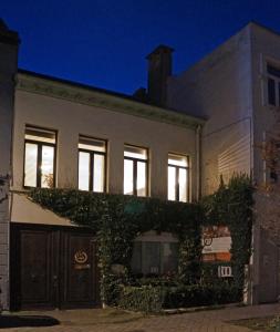 a house with ivy on the side of it at night at l'ostendaise in Ostend