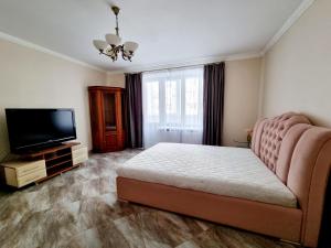 a bedroom with a bed and a flat screen tv at Forrest for 8 person in Luts'k