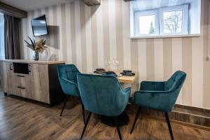 een kamer met een tafel en stoelen en een televisie bij Hotel Demanova Apartments Dependance in Liptovský Mikuláš