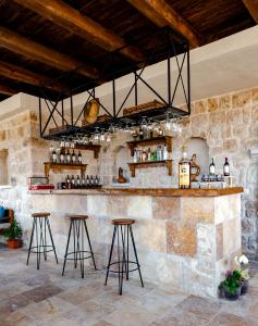 a stone bar with stools and a chandelier at Cappadocia hotel Megaron cave in Ortahisar