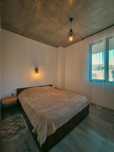 um quarto com uma cama grande e uma janela em Eco Garden Kutaisi em Kutaisi