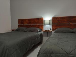 a bedroom with two beds and a table with a lamp at Your Bedroom in Puerto Peñasco