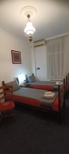 een slaapkamer met 2 bedden en een kroonluchter bij Authentic Belgrade Centre Hostel - Only private rooms in Belgrado