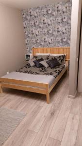 a bedroom with a bed with a wooden headboard at Cenkones Street Apartment in Liepāja