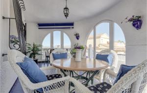 ein Esszimmer mit einem Tisch, Stühlen und Fenstern in der Unterkunft Stunning Home In Gran Alacant With Outdoor Swimming Pool in Santa Pola