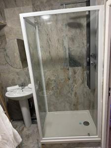 une douche avec une porte en verre à côté d'un lavabo dans l'établissement Golden Love - Jacuzzi, à Rouen
