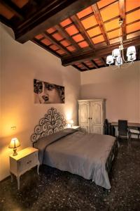 a bedroom with a bed and a painting on the wall at Le stanze dei Ghibellini in Florence