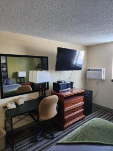 a hotel room with a desk and a bed and a computer at Bison Plains Lodge in Moorhead