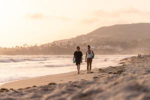 ラグーナ・ビーチにあるSCP Seven4One Hotelの海岸を歩く二人
