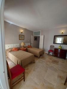 una habitación de hotel con 2 camas y una silla en Casa Manduca Delicata en La Valeta