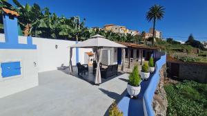 a house with a patio with an umbrella at Casa Marcos in La Gomera with relaxing terrace in Agulo