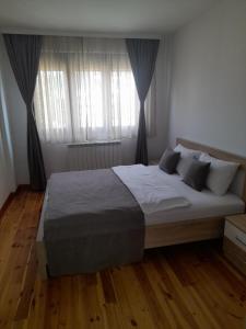 a bedroom with a large bed and a window at Apartments Gorska in Kolašin +18 photos