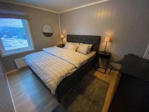 ein Schlafzimmer mit einem Bett mit zwei Lampen und einem Fenster in der Unterkunft New modern apartment with great view - ski in & out in Skulestadmo